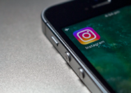 Ilustrasi ponsel dengan layar Instagram yang menampilkan berbagai konten visual dan pengguna aktif.
